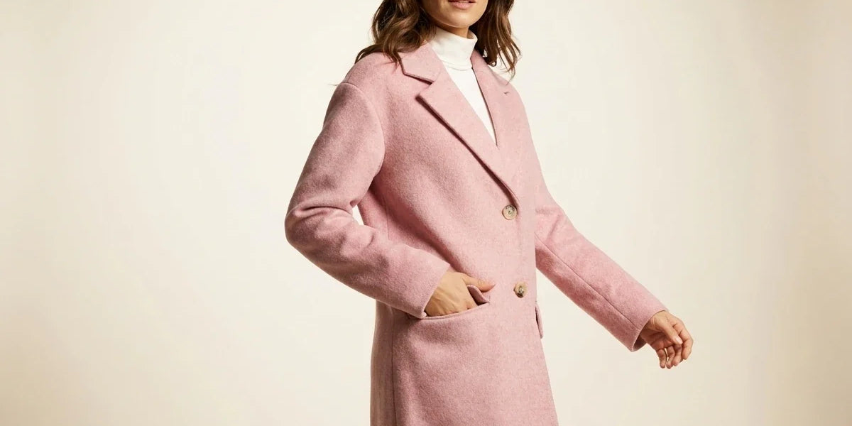 Brunette woman modeling a Charter Club blush pink wool-blend tailored coat over a white turtleneck in a studio setting.