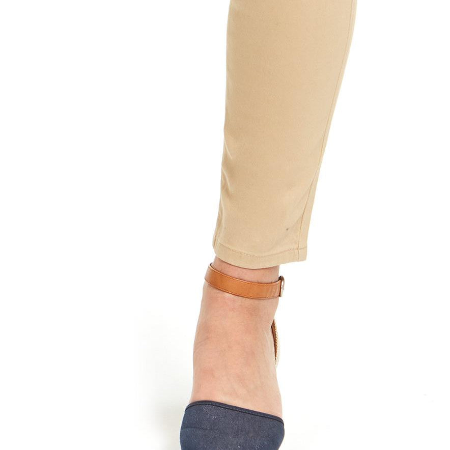 Denim wedge sandal worn with beige pants on a white background