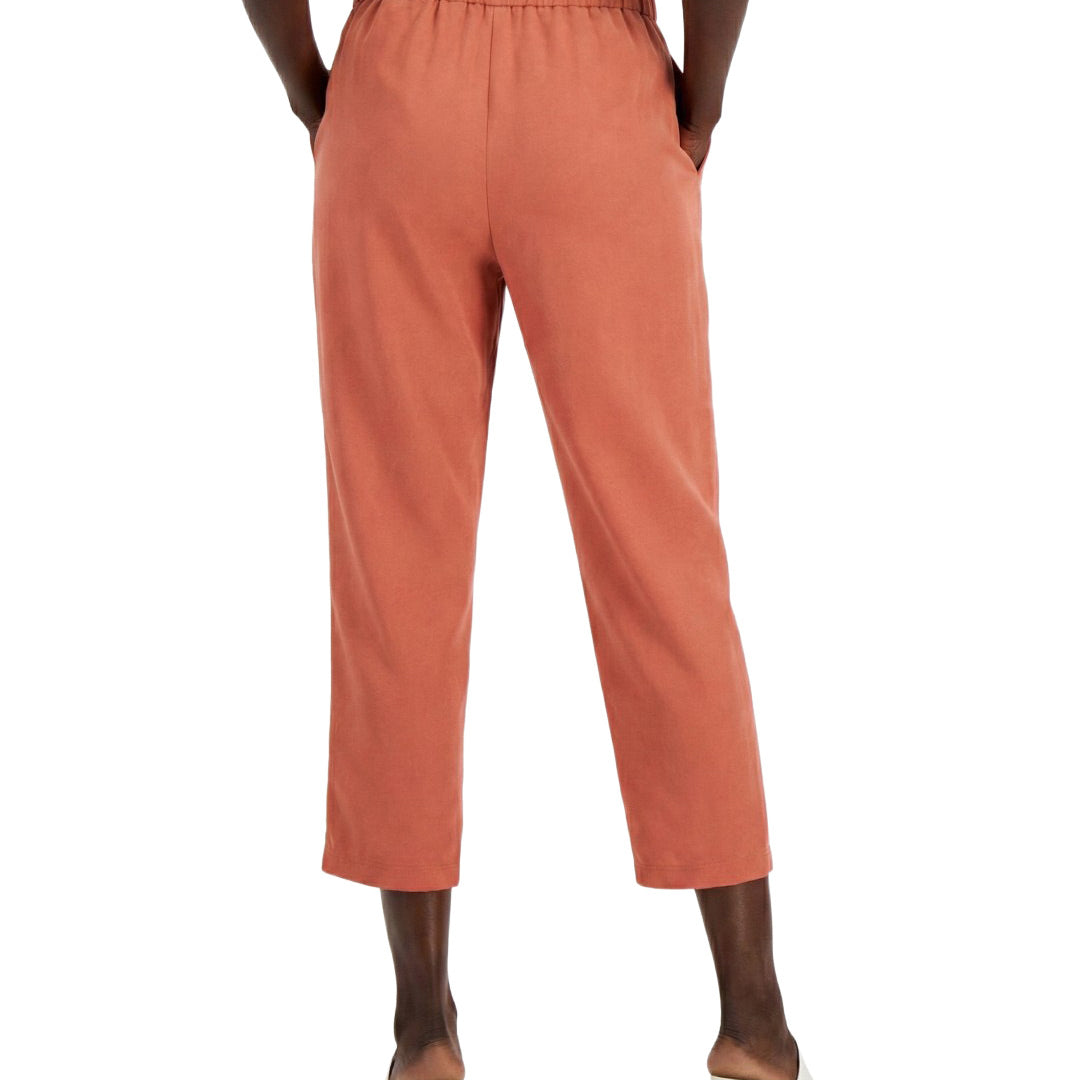 Person wearing coral pants on a white background