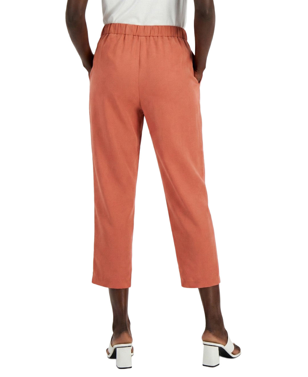 Person wearing coral pants on a white background