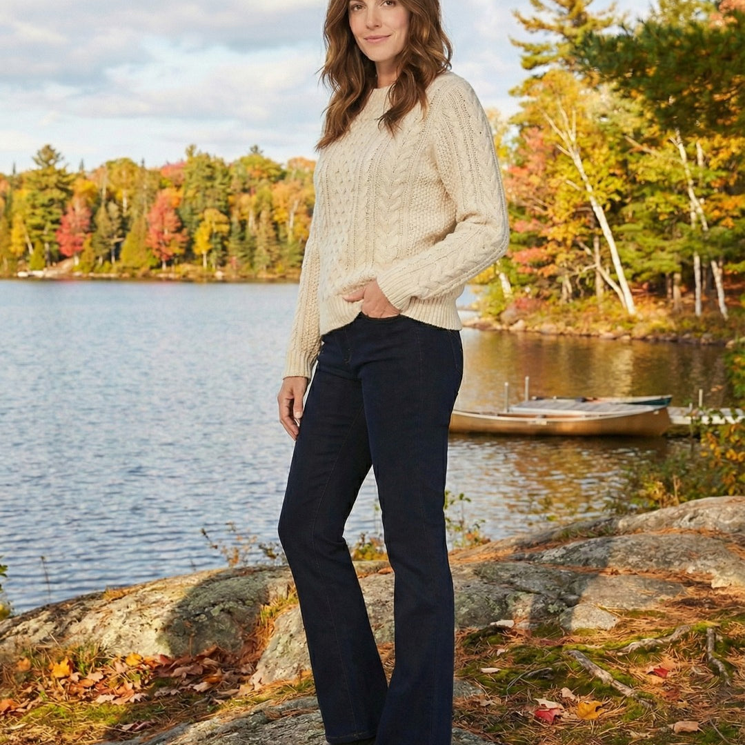Woman standing by a lake with autumn foliage