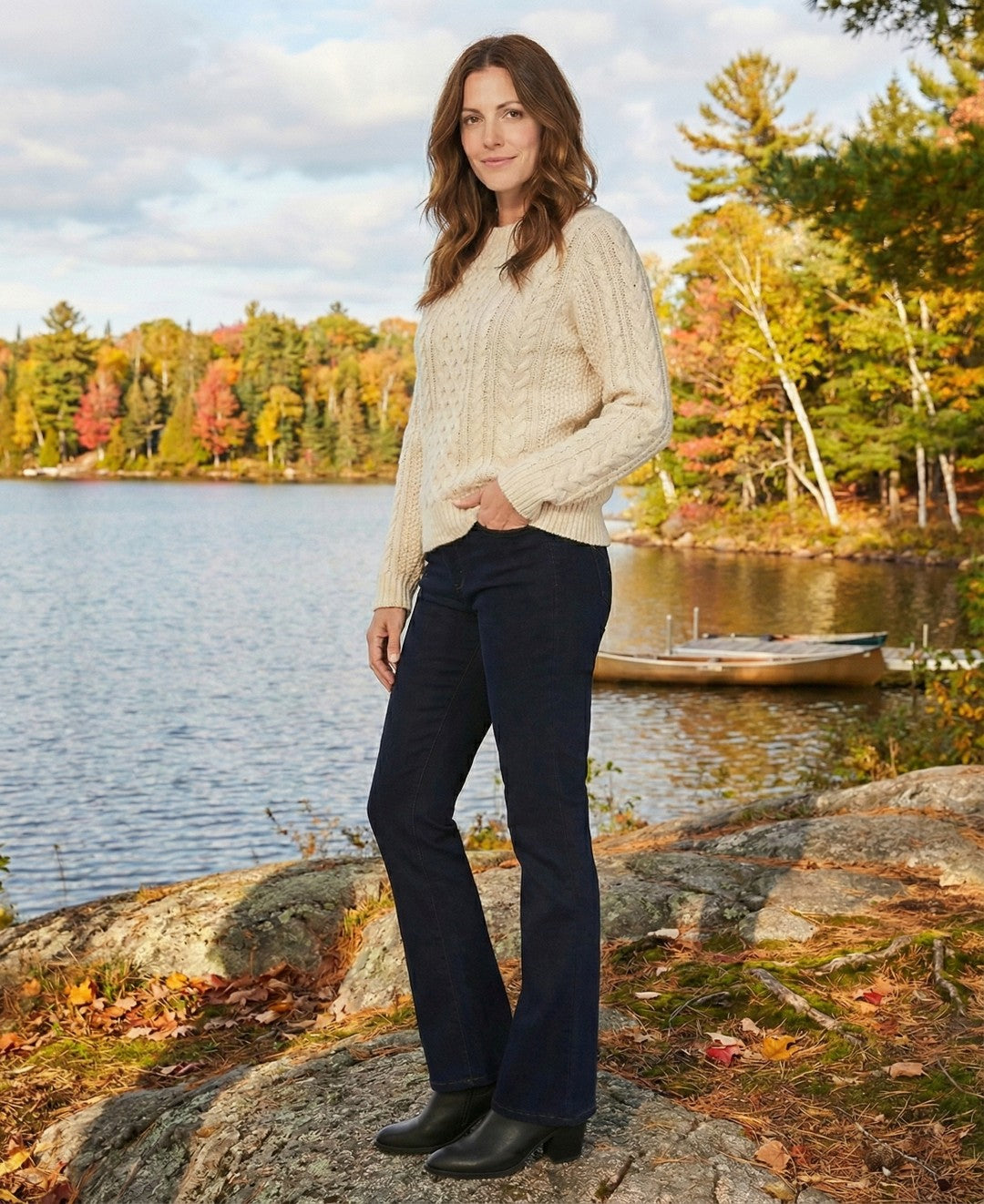 Woman standing by a lake with autumn foliage