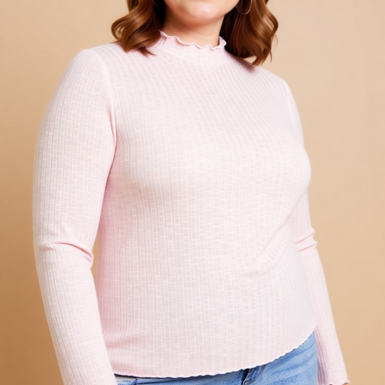 Woman wearing a light pink sweater and blue jeans against a beige background