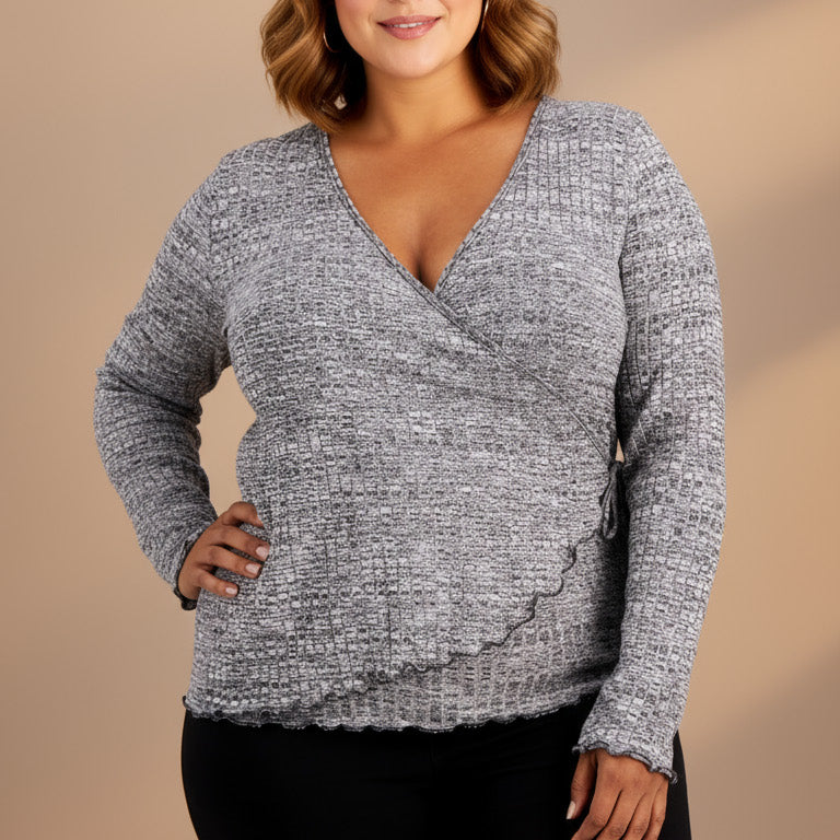 Woman wearing a gray sweater with a plain background