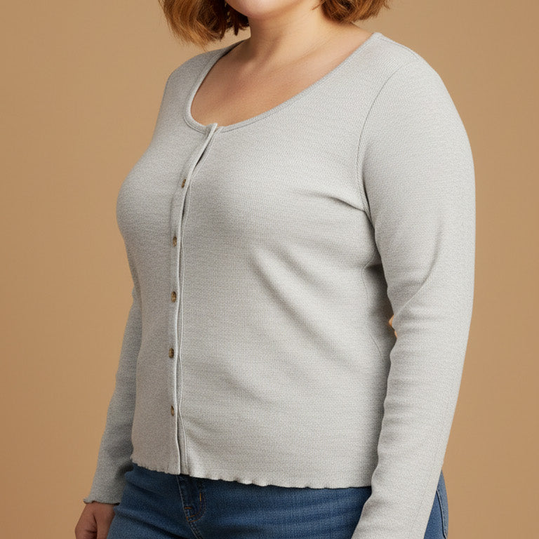 Woman wearing a light gray cardigan and blue jeans on a beige background