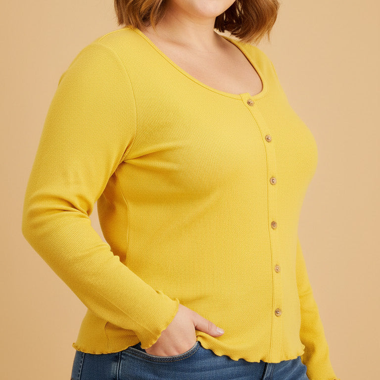 Woman wearing a yellow long-sleeve top and blue jeans on a beige background