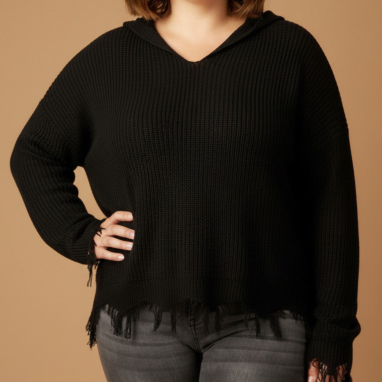 Woman wearing a black hoodie with fringe details on a brown background