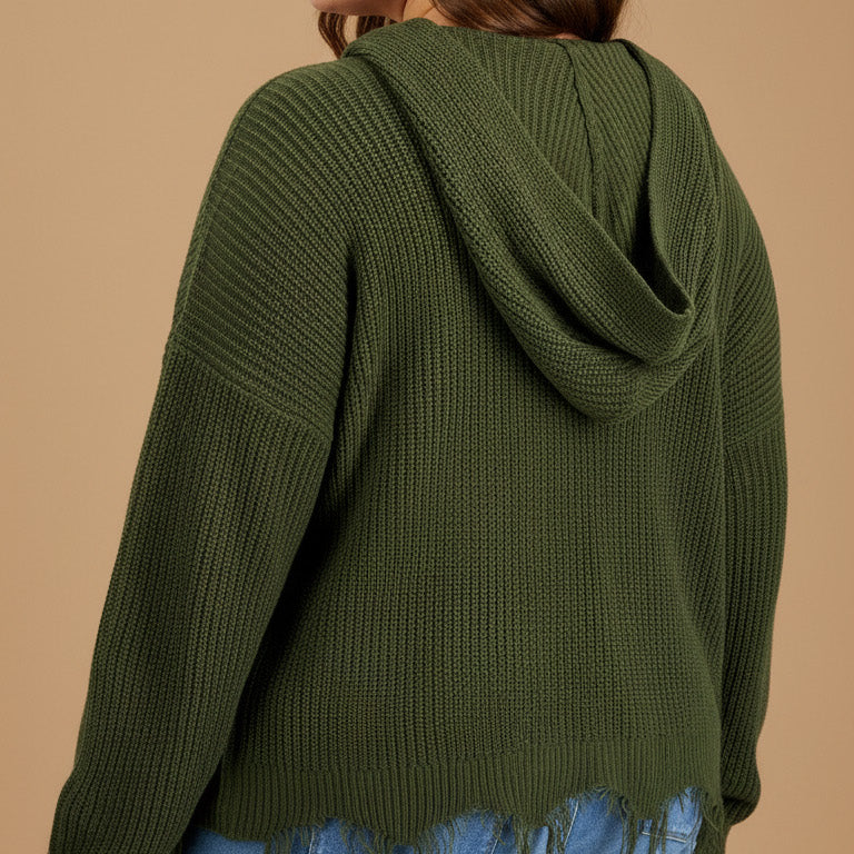 Woman wearing a green hoodie and blue jeans on a beige background