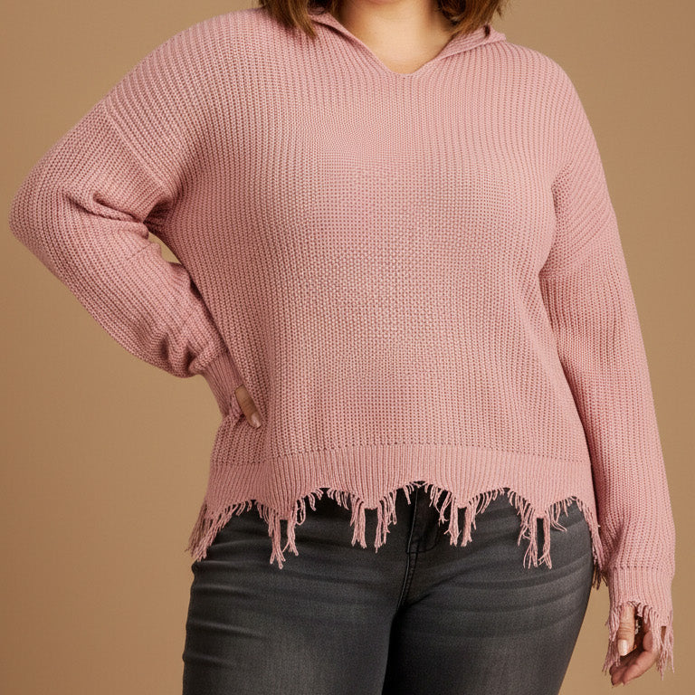 Woman wearing a pink sweater with distressed hem against a beige background