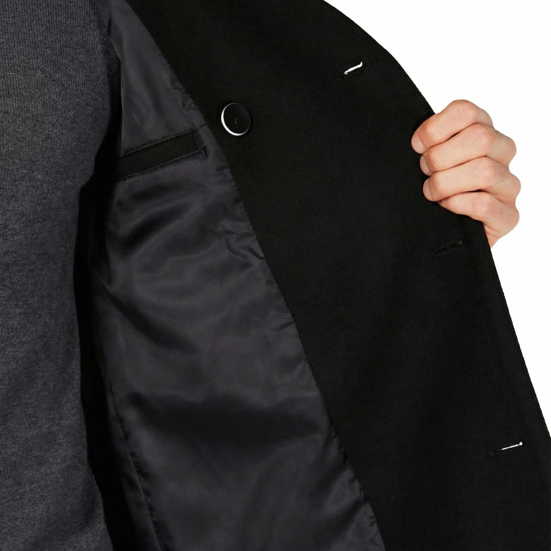 Close-up of a person wearing a black coat with a gray sweater underneath, on a white background.