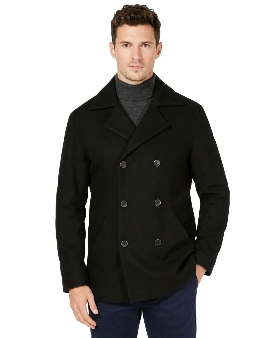 Man wearing a black peacoat on a white background