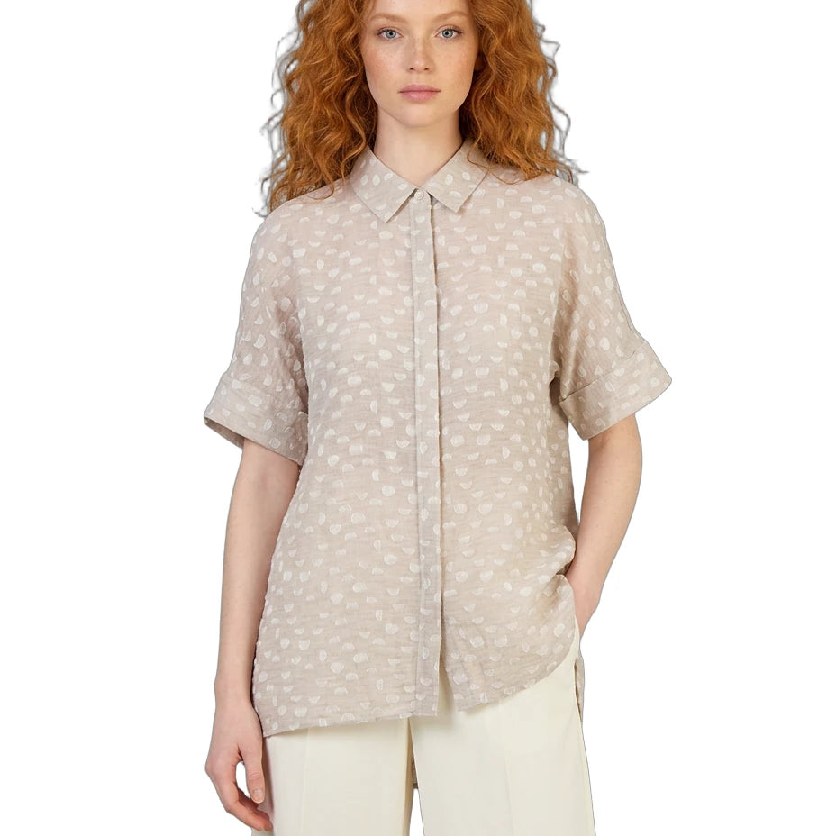 Woman wearing a beige patterned shirt on a white background