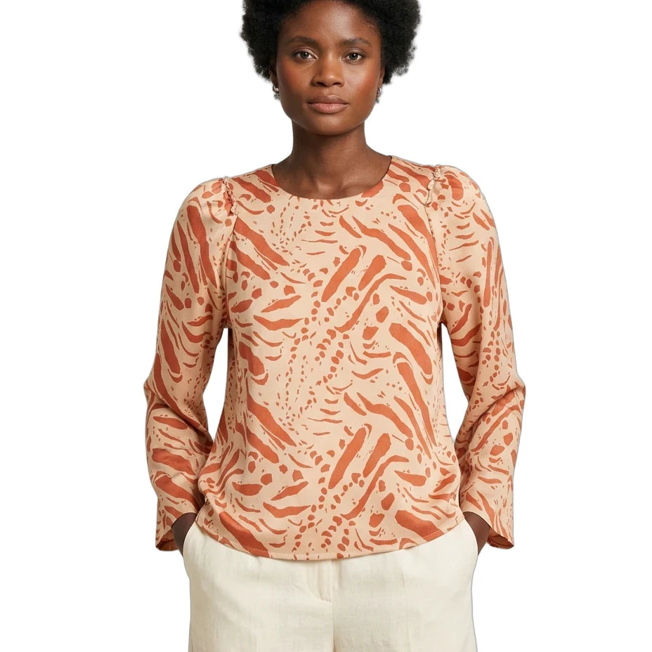 Woman wearing a patterned long-sleeve top on a white background