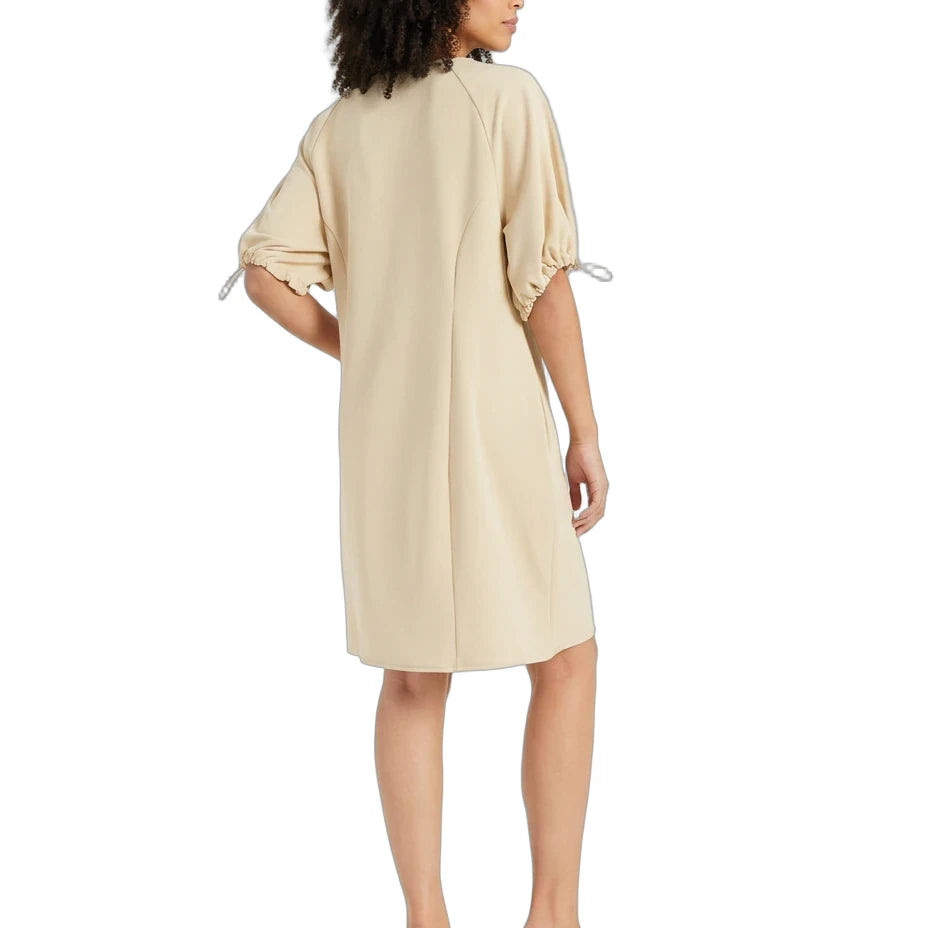 A woman modeling a light beige midi dress from the back, featuring short puff sleeves with tie details, on a solid white background.