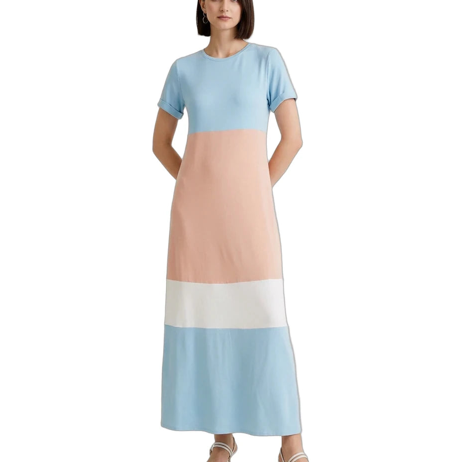 A woman modeling a short-sleeve maxi dress with a colorblock design in light blue, peach, white, and light blue, paired with white heeled sandals against a plain white background.