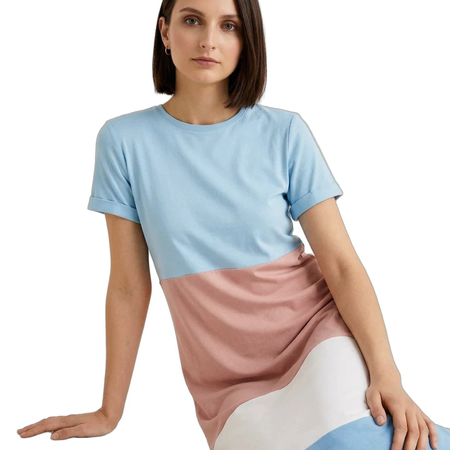 A woman wearing a color-block short-sleeve dress with light blue, dusty pink, and white panels, posed against a solid white background.