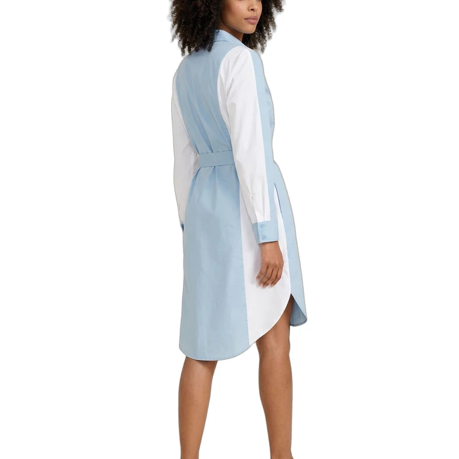 A woman modeling a light blue and white color-blocked shirt dress, shown from a side-back angle against a plain white background.