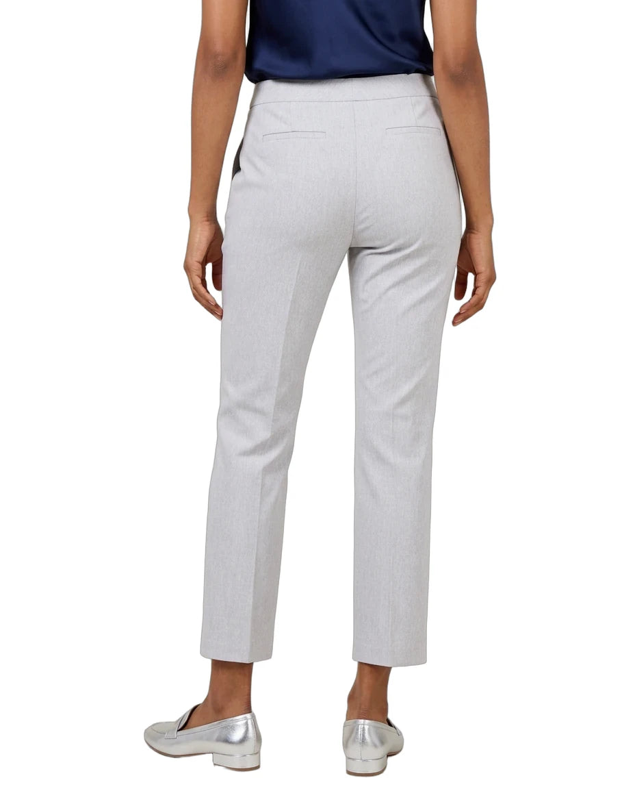 A person shown from the back wearing light gray cropped trousers, a navy top, and metallic silver loafers against a plain white studio background.