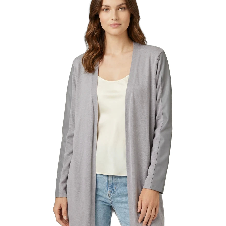 Woman wearing a gray cardigan over a white top and blue jeans on a white background