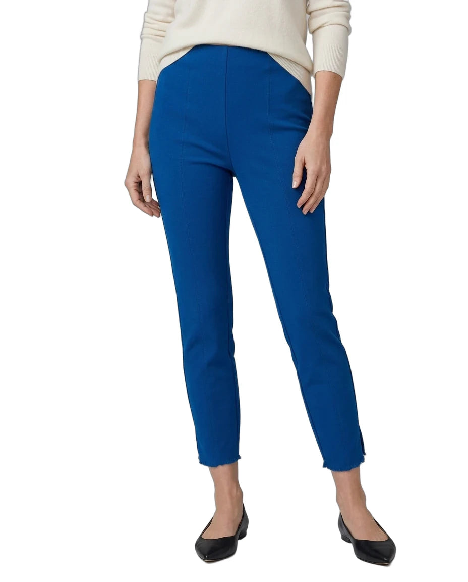 A model wearing bright royal blue cropped pants, paired with a cream long-sleeve top and black flats, shown against a plain white background.