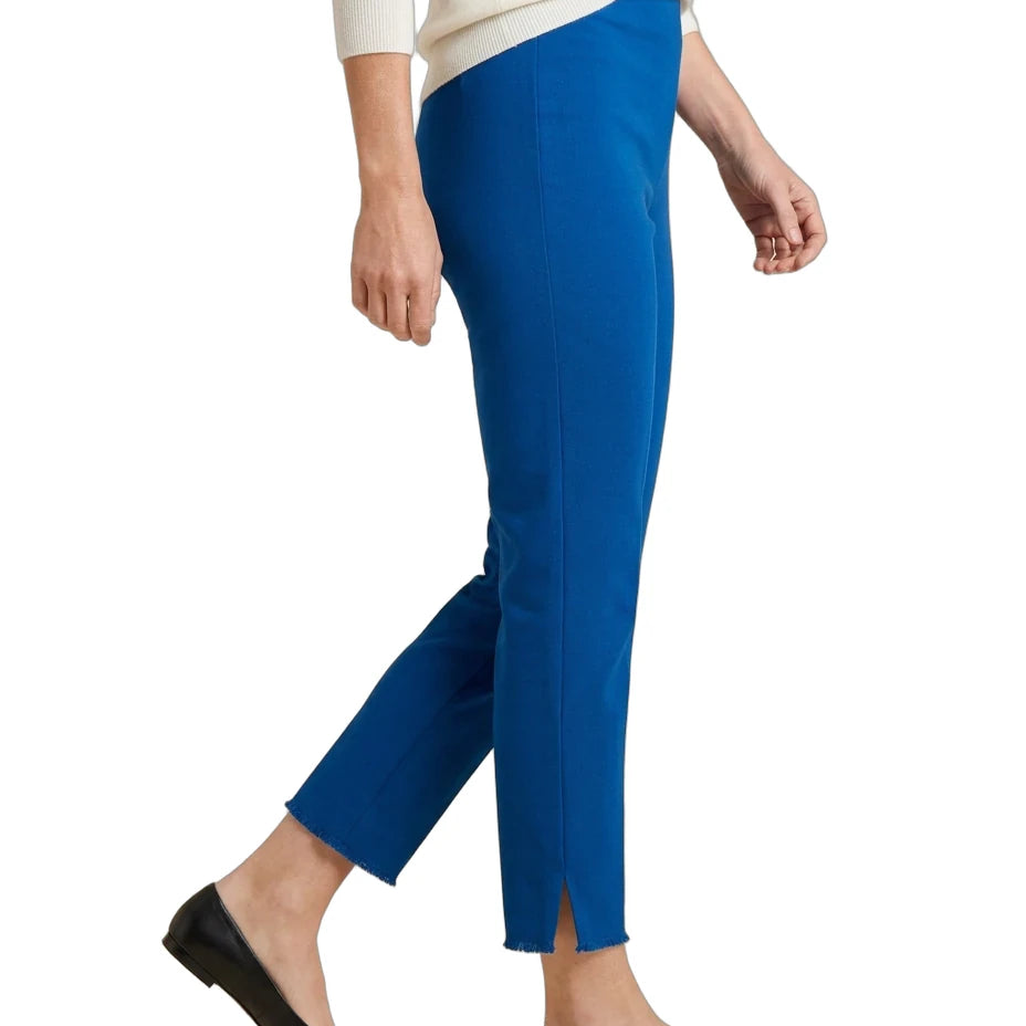 A person wearing bright royal blue cropped pants with side slits, styled with a cream sweater and black flats against a plain white background.