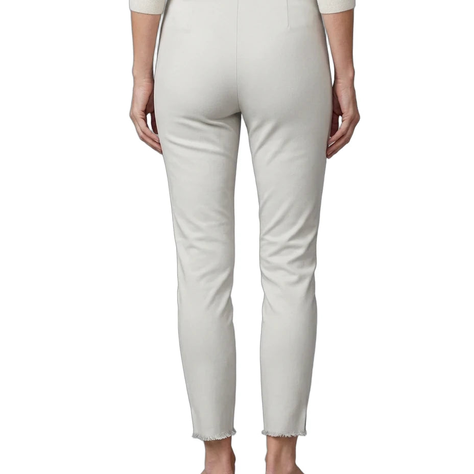 A person shown from the back wearing light cream cropped trousers with a frayed hem, paired with a cream long-sleeve top and black flats, against a plain white background.