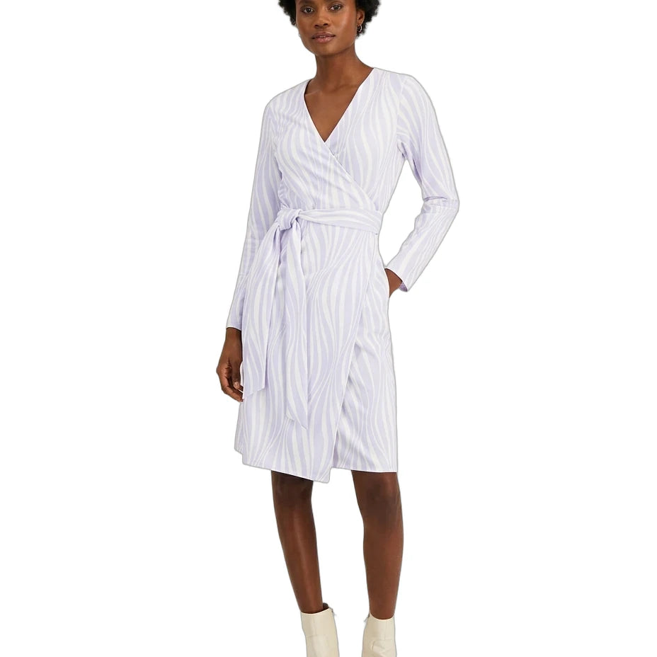 A woman modeling a white wrap dress with thin vertical blue stripes, featuring a V-neck, long sleeves, and a self-tie belt, paired with off-white ankle boots against a plain white background.