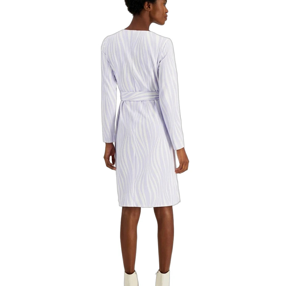 A woman shown from the back wearing a white long-sleeve belted dress with a subtle vertical wavy stripe pattern, paired with white ankle boots, against a plain white background.