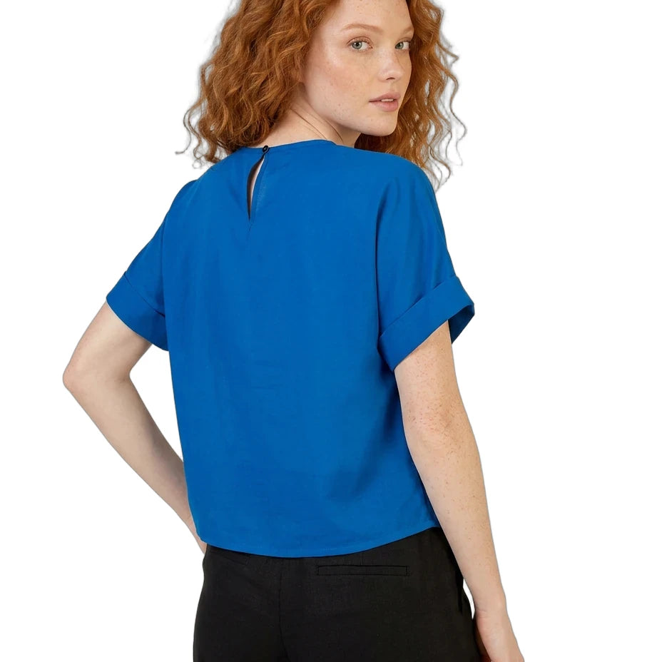 Woman wearing a blue top and black pants on a white background