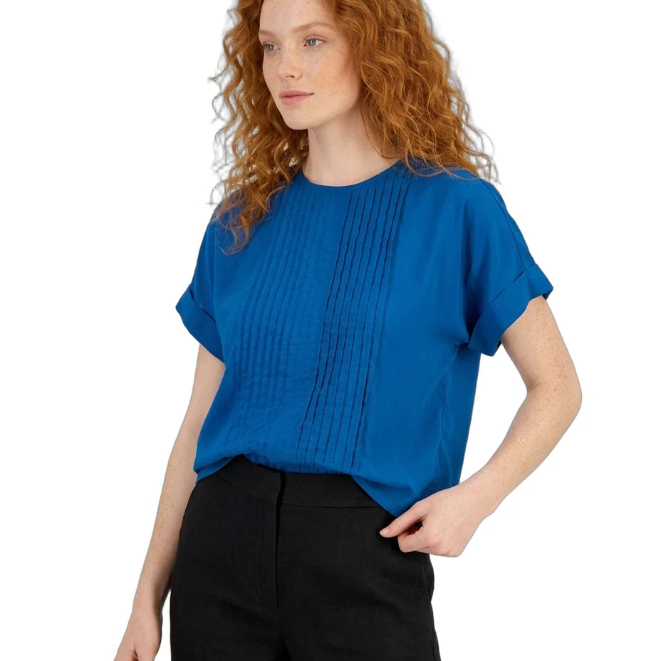 Woman wearing a blue top and black pants on a white background