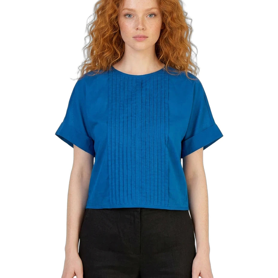 Woman wearing a blue top and black pants on a white background