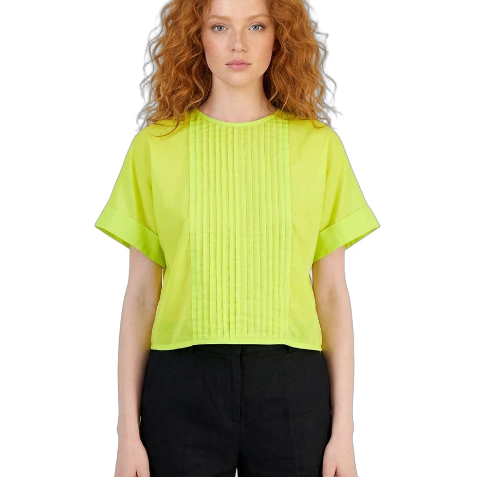 Woman wearing a bright green blouse and black pants on a white background
