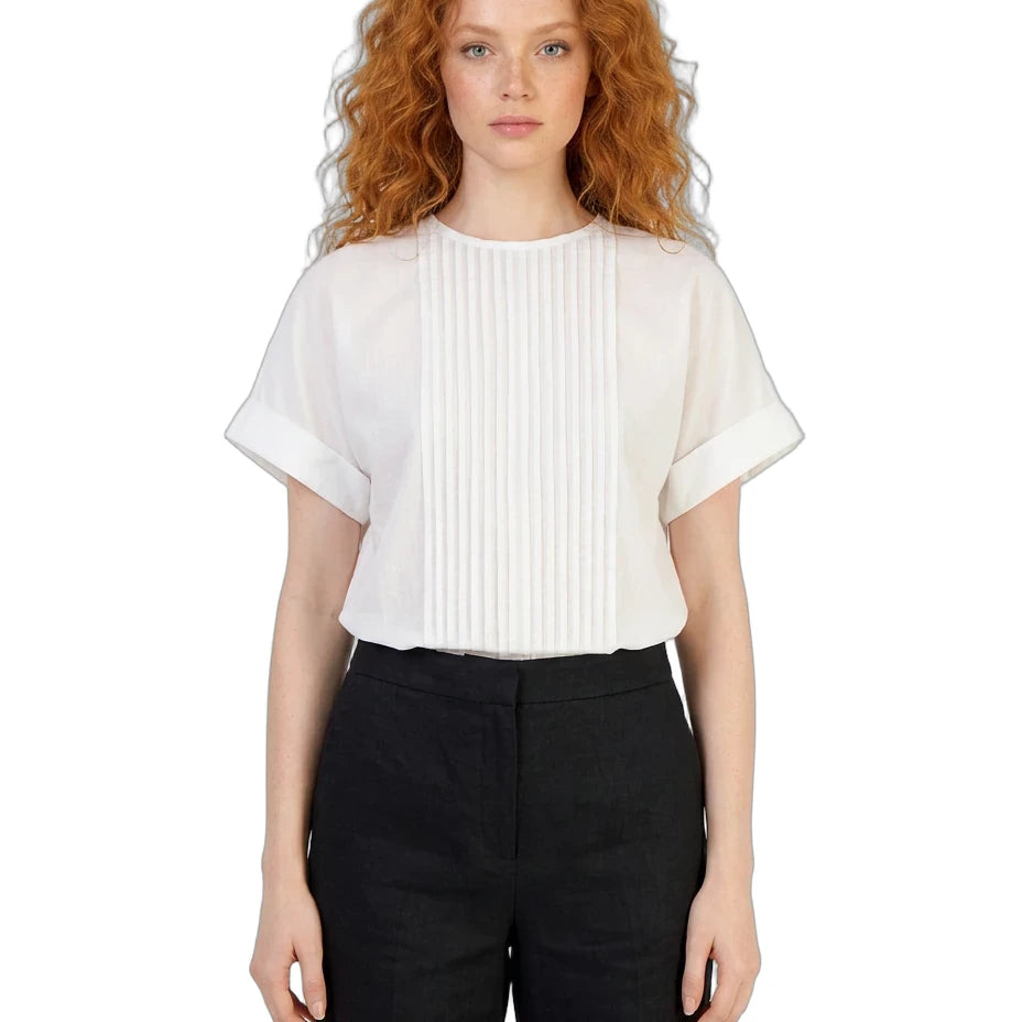 Woman wearing a white blouse with ruffled sleeves and black pants on a white background
