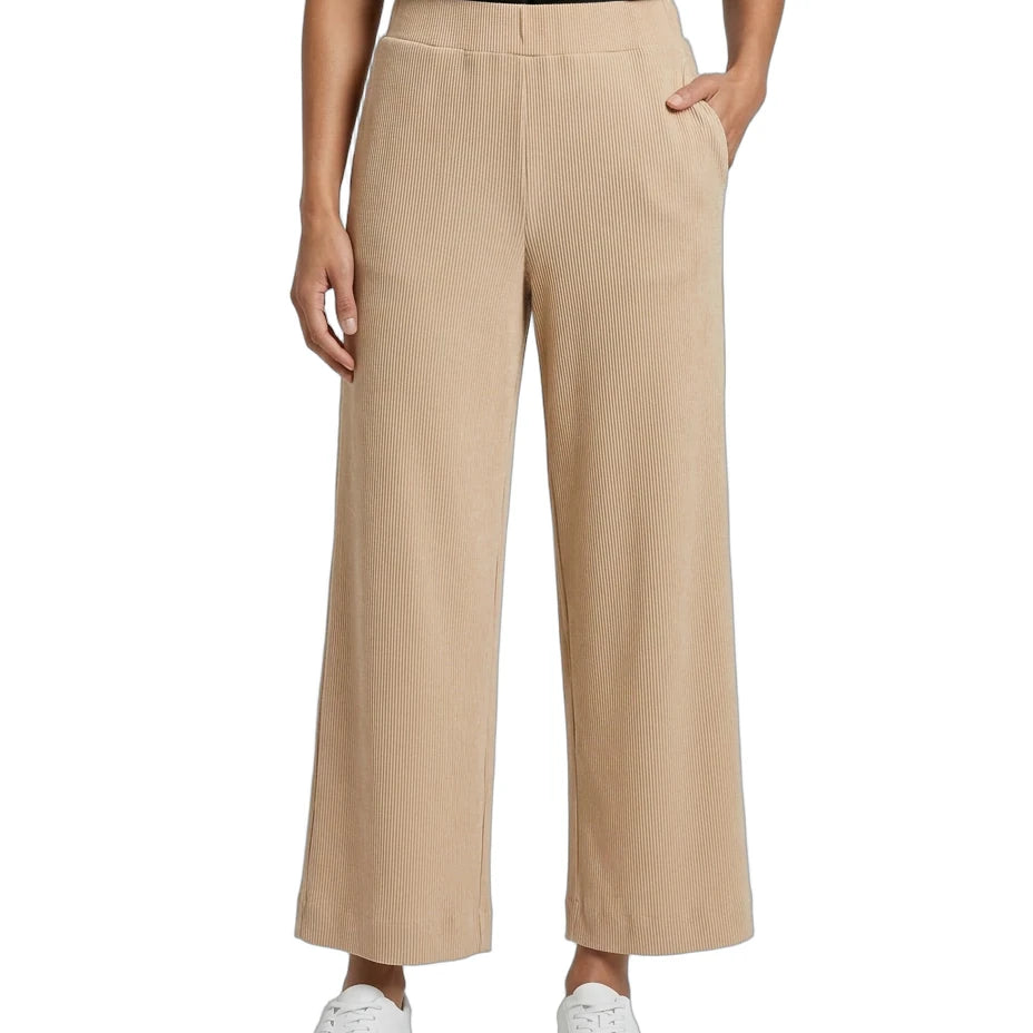 A model wearing beige wide-leg cropped trousers with a black satin top and white sneakers, shown from the waist down on a white background.