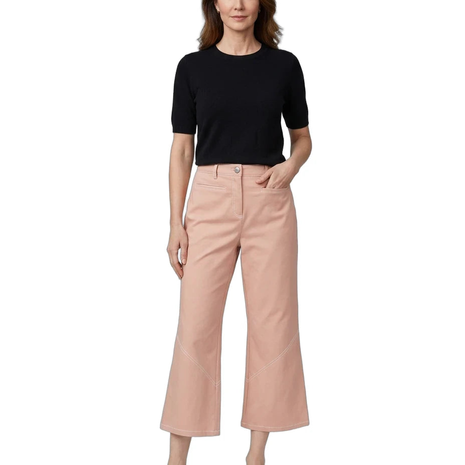 A woman modeling a black short-sleeve crewneck top and light pink cropped wide-leg pants with white slide sandals, set against a plain white background.