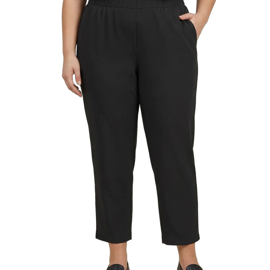 A model wearing black cropped pants with an elastic waistband, paired with a dark gray top and black loafers, shown against a plain white background.