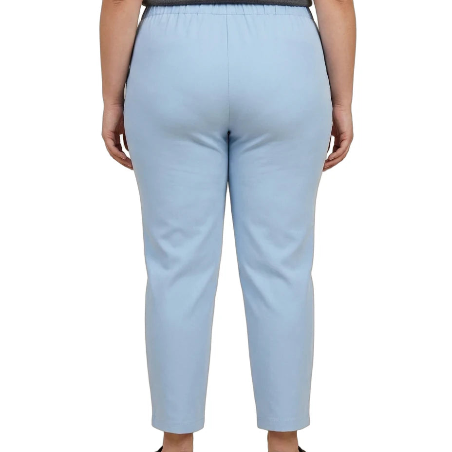 A person shown from the back wearing light blue cropped pants, a dark gray top, and black flats against a plain white studio background.