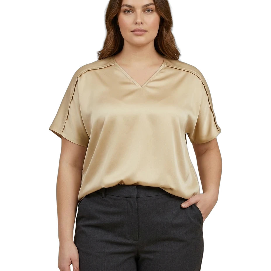 Woman wearing a beige blouse and black pants on a white background