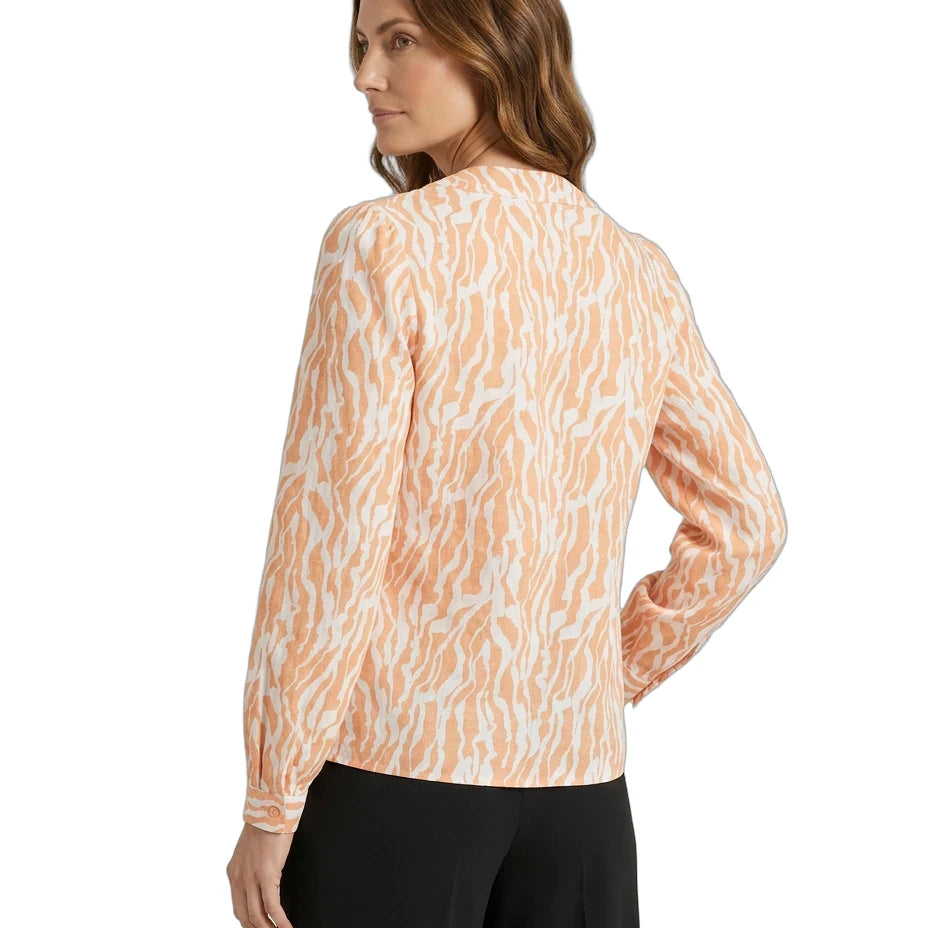 Woman wearing a long-sleeve, patterned blouse with a white background
