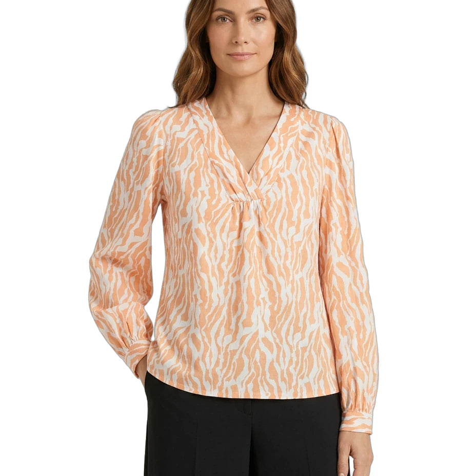 Woman wearing a patterned blouse with long sleeves on a white background