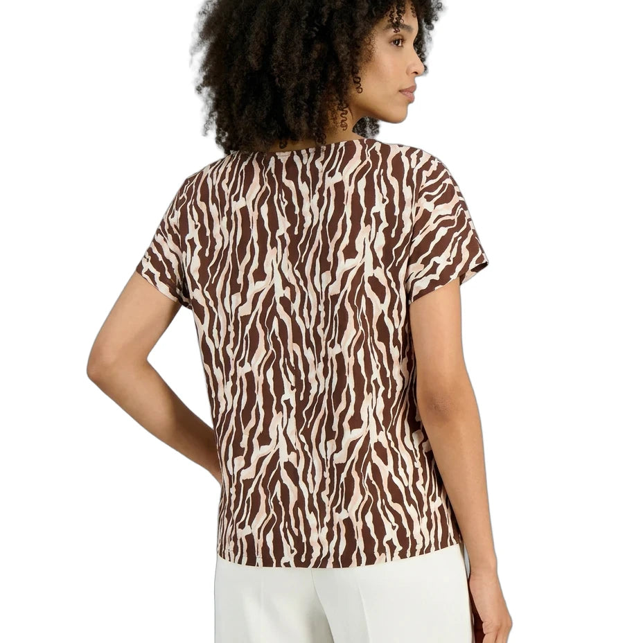 Woman wearing a zebra print top on a white background
