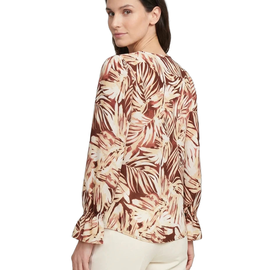 Woman wearing a patterned blouse with a white background