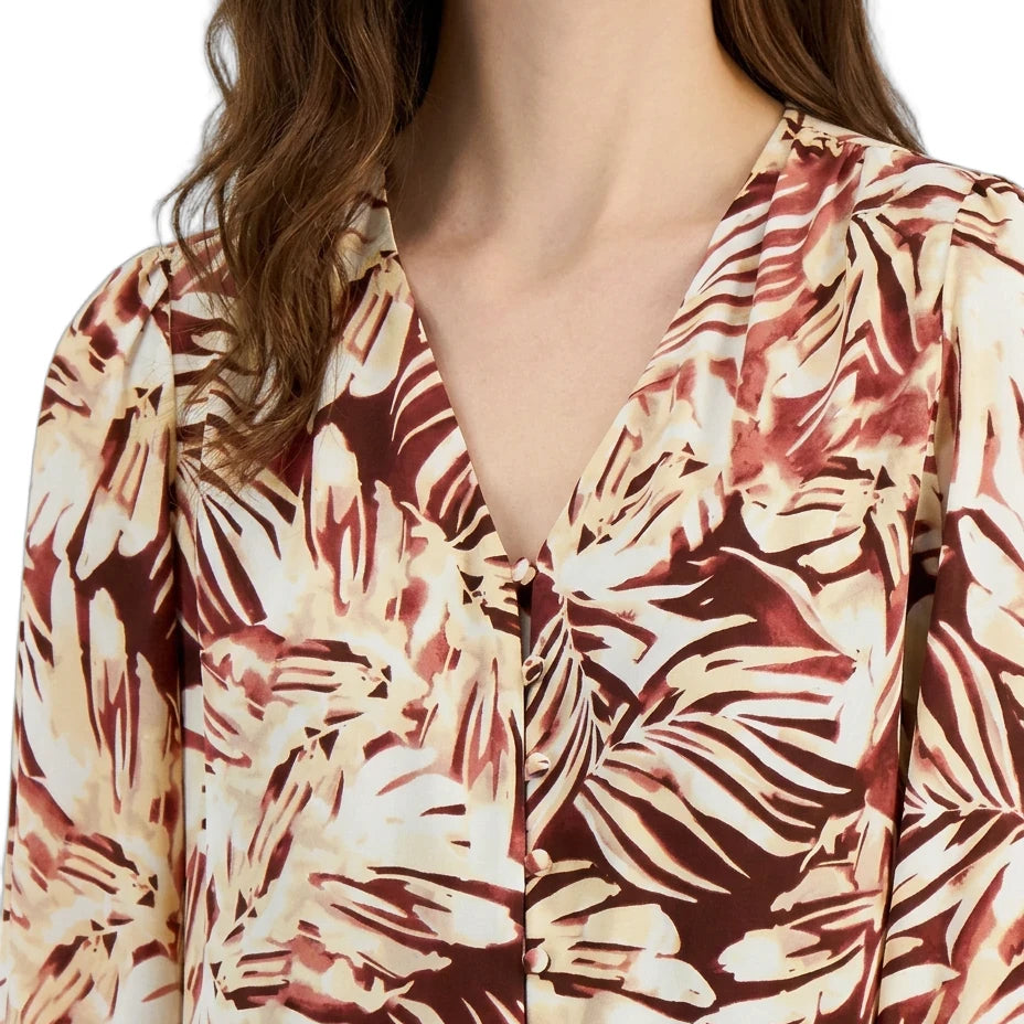 Woman wearing a floral patterned blouse with a plain background
