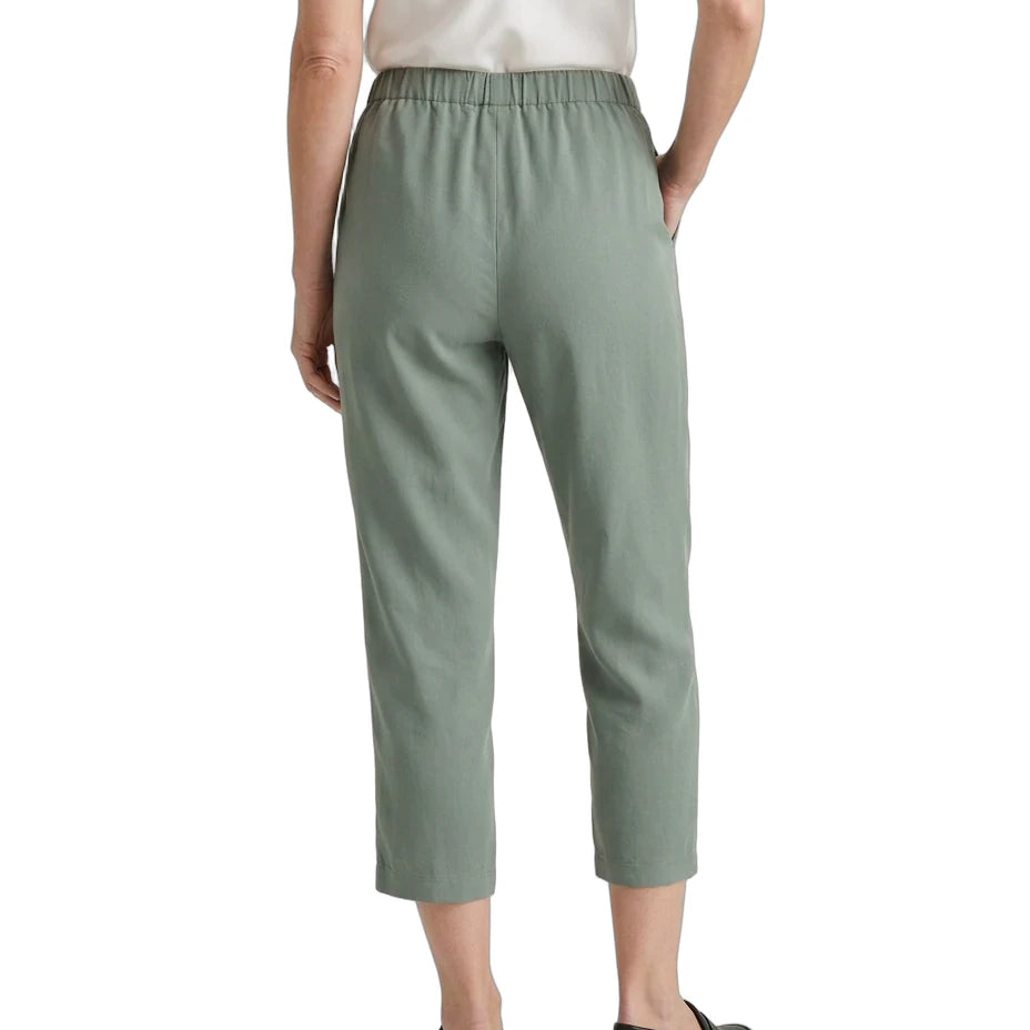 A model shown from the back wearing sage green cropped trousers, a white camisole top, and black loafers against a plain white background.