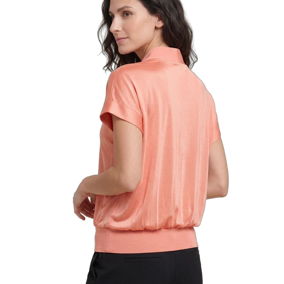 Woman wearing a peach-colored short-sleeve blouse on a white background