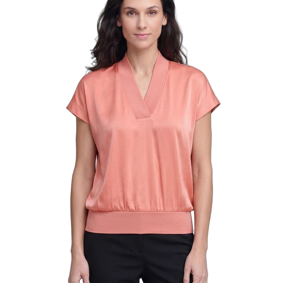 Woman wearing a coral blouse with a white background