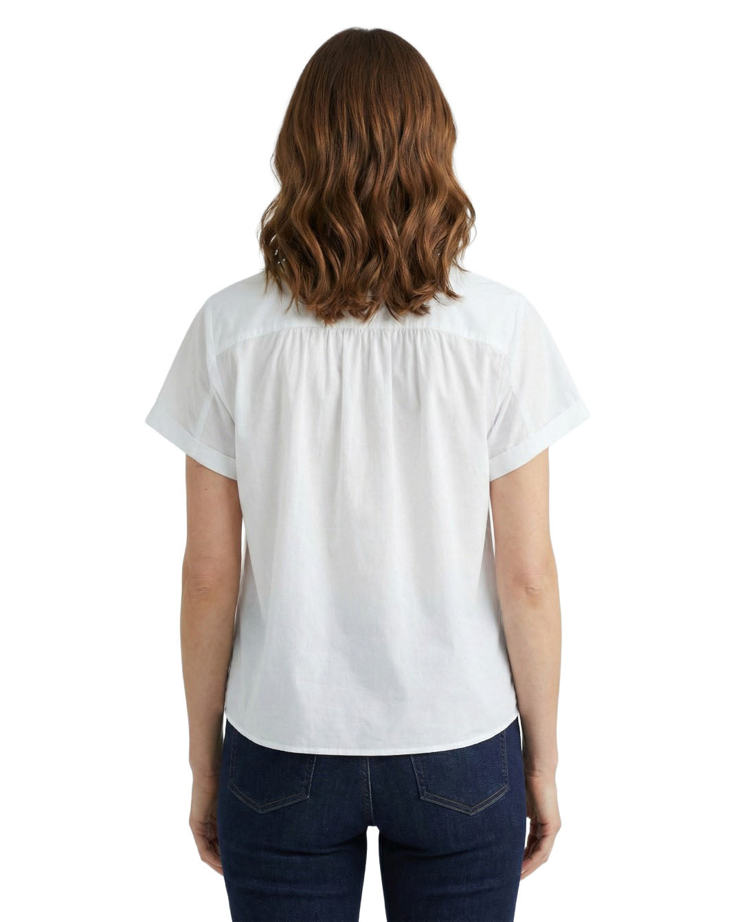 Woman wearing a white blouse and dark jeans on a white background