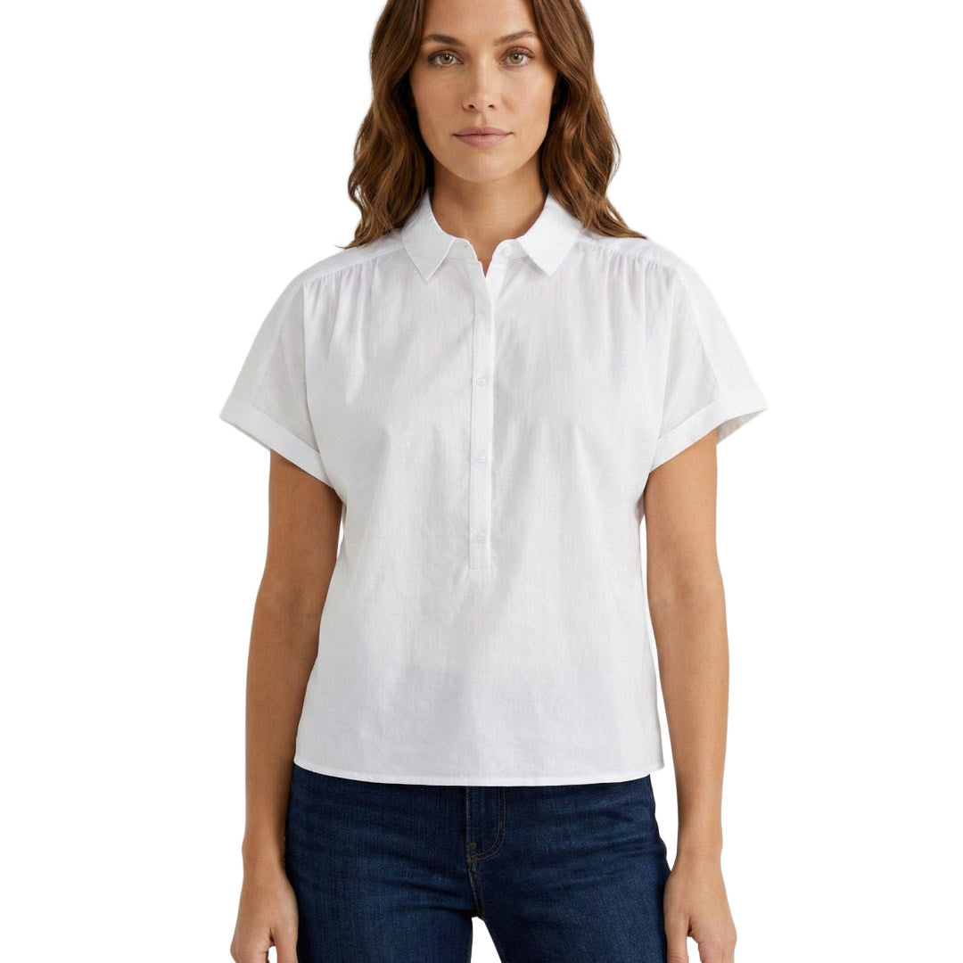 Woman wearing a white short-sleeve blouse and dark jeans on a white background