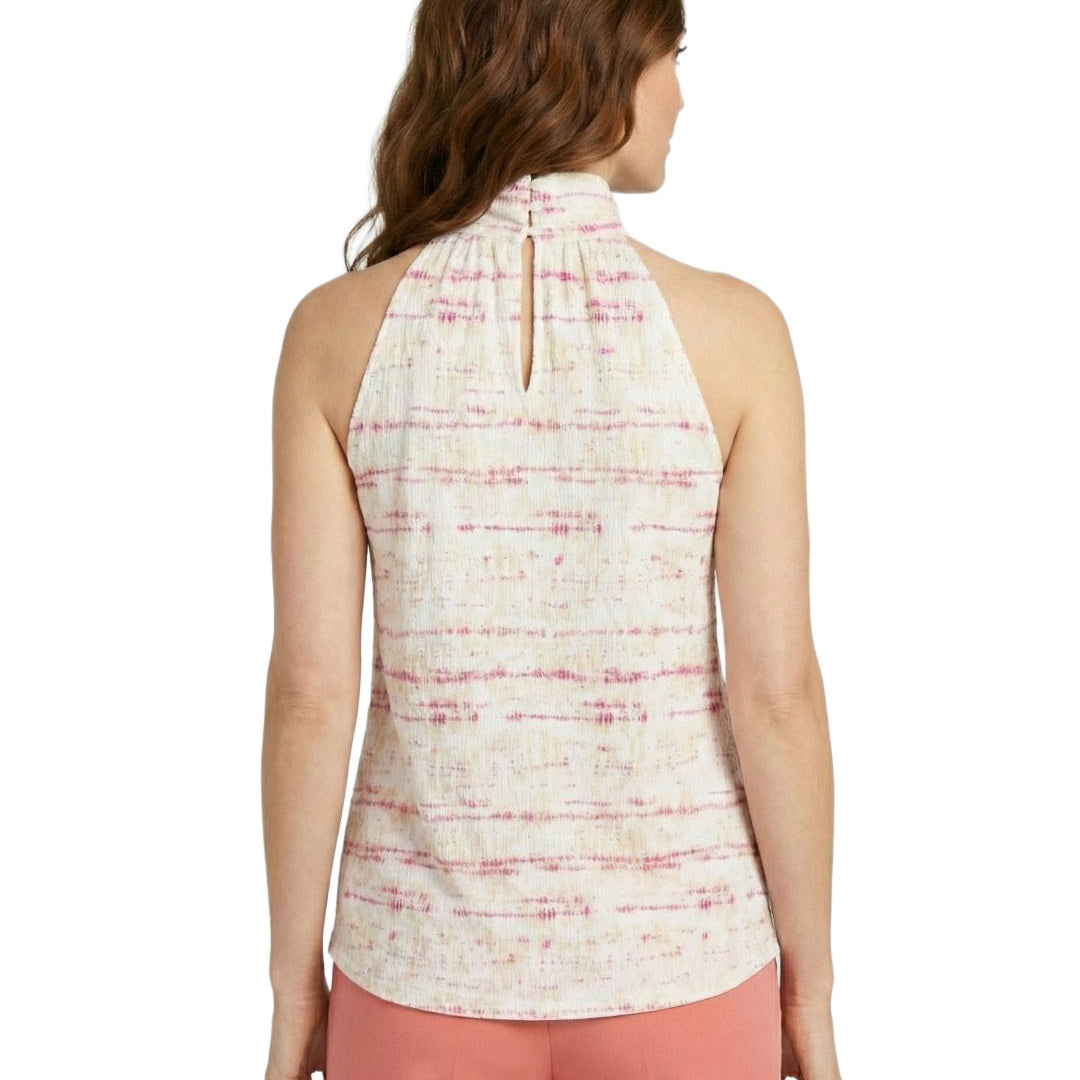 Woman wearing a sleeveless patterned top and pink pants on a white background