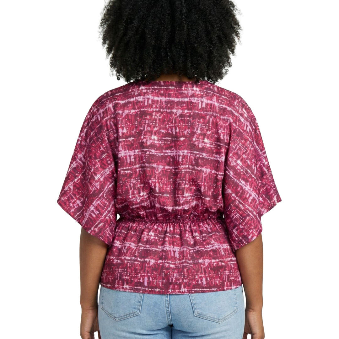Person wearing a red and white patterned blouse with blue jeans on a white background